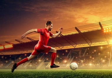 Futbol stadyumunda iş başında olan futbolcu. Aydınlatma ve tribünler ile ışıklandırılmış gece alanı. Gece dramatik gökyüzü