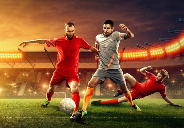 三名足球运动员在职业球场与球迷争球 — 图库照片