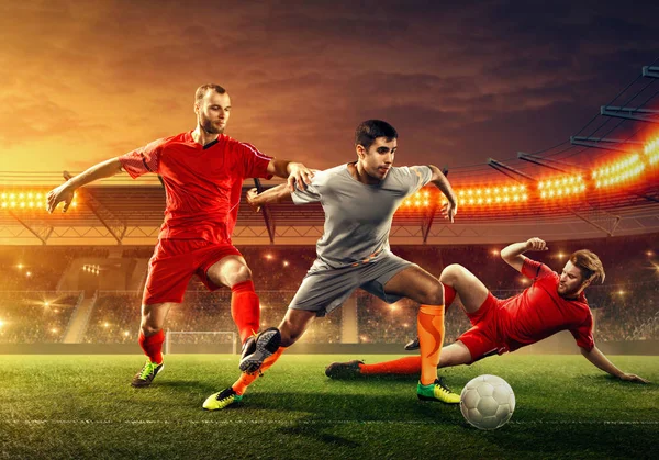 三名足球运动员在职业球场与球迷争球 — 图库照片