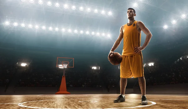 身着运动服的职业篮球运动员在灯光下篮球场上拿着球 — 图库照片
