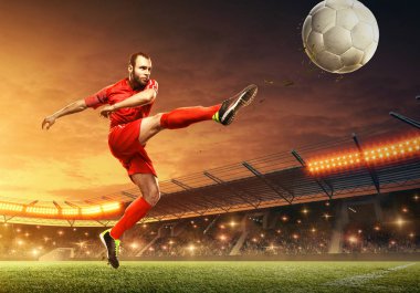Futbolcu iş başında. Seyirci ve gece dramatik gökyüzü ile Futbol stadyumu