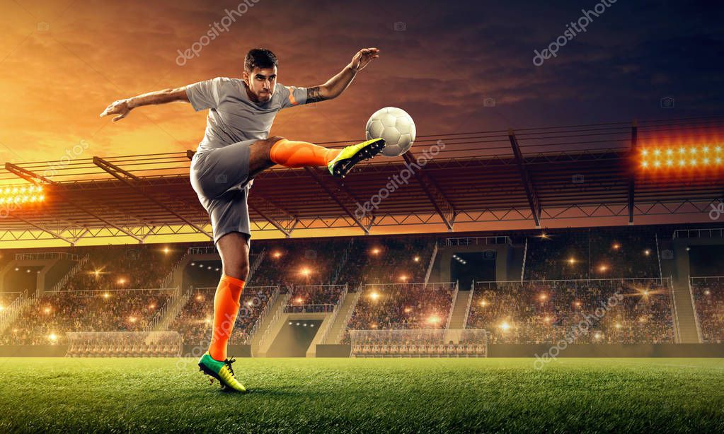 El jugador de fútbol patea la pelota. Estadio de fútbol con