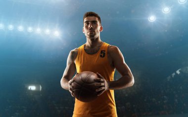 Professional young basketball player holds the ball on a floodlit court clipart