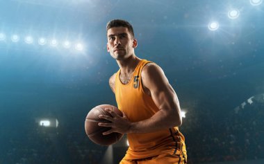 Young, muscular professional basketball player with the ball ready to make a shot. Floodlit background clipart