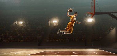 Baketball oyuncusu smaç yapıyor. Lay-up atış. Işıklı basketbol sahası