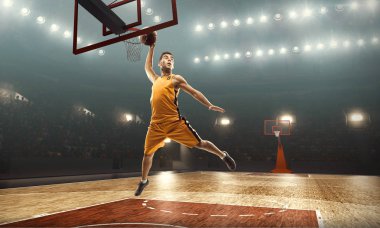 Baketball oyuncusu smaç yapıyor. Lay-up atış. Işıklı basketbol sahası