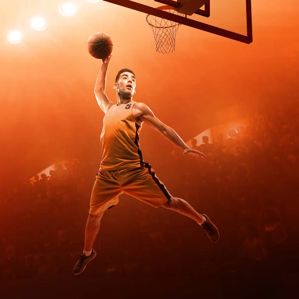 Basketball player in sports uniform on a professional basketball court in action with the ball. Slam dunk. Red floodlit background