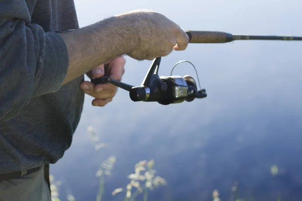 釣り人は 回転のための魚をキャッチします 紡ぎ車と釣り糸を引っ張る — ストック写真