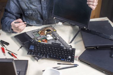 Computer service. Service technician. Opening the laptop. Screen replacement. clipart