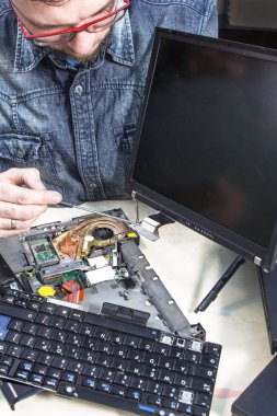 Dizüstü ekran yerine. Servis teknisyeni ve menteşe tutan vidayı unscrews. Kaldırılan klavye yanında olduğunu
