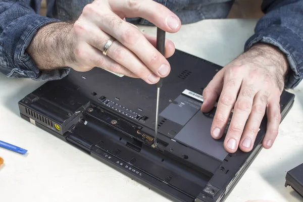 Unscrewing the laptop casing on the computer service.