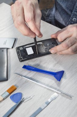 Elinde bir telefon hizmeti çalışan unscrews hareket eden telefon içinde vida.