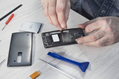 Bir telefon hizmeti çalışan eller unscrews hareket eden telefon içinde vida.