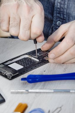 Elinde bir telefon hizmeti çalışan unscrews hareket eden telefon içinde vida.