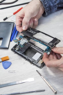 Adamın elleri cep telefonu inşa öğeleri tutun.