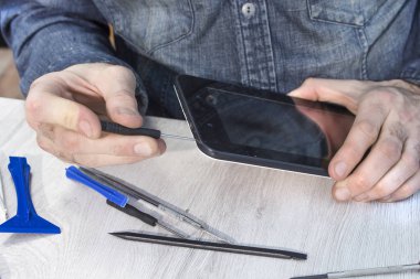 Onarım bozuk bir tablet bir elektronik hizmet. Elektronik hizmet çalışan kırık tablet unscrews.