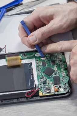 Elektronik hizmet istasyonunda çalışıyorum. Tablet onarım. Sitede bir çalışan tarafından vida açılmış tablet.