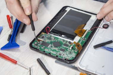 Elektronik hizmet çalışan kırık tablet unscrews.
