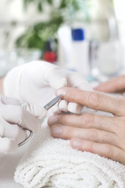 Adam bir manikür işlemi sırasında bir güzellik salonu. Derileri el çiviye makasla kesme.. 