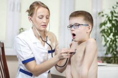 Çocuk çocuk doktoru ofiste muayene sırasında. Bir doktor ofisinde muayene göğüs stetoskop ile. Çocuk açık ağızlı derin nefes alır.