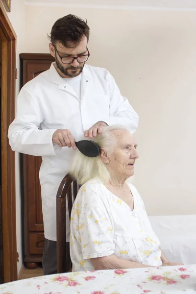 Enfermero Peina Pelo Una Anciana Sentada Una Silla Cuidado Personas — Foto de Stock