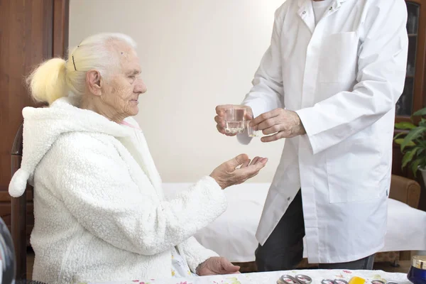 Enfermeiro Copo Medicamentos Copo Água Uma Mulher Idosa — Fotografia de Stock