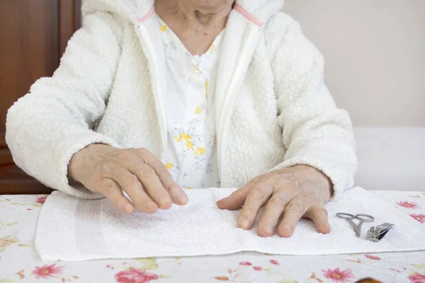 Hands of an old woman prepared for a cosmetic treatment. An old woman gives her hand during a cosmetic treatment.