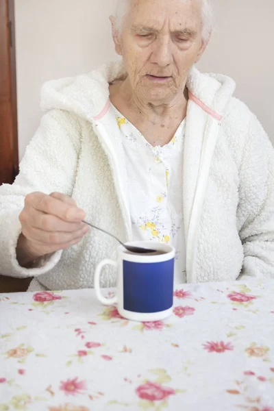 Anciano Canoso Sienta Mesa Toma Una Taza Una Cucharadita — Foto de Stock