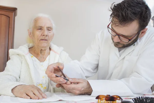 Enfermero Con Una Bata Blanca Corta Las Uñas Una Anciana — Foto de Stock