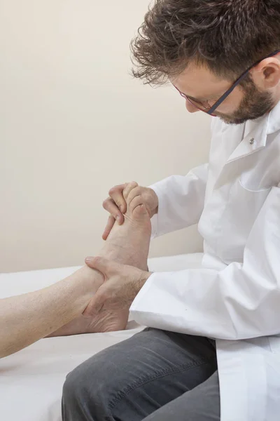 Médico Ortopedista Examina Pie Una Anciana Acostada Una Cama —  Fotos de Stock