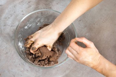 Kadınların elleri zencefilli kurabiye hamur hamur işleri Noel için yapmak. Bir cam kase maddeler ile mutfak tezgahına standları.