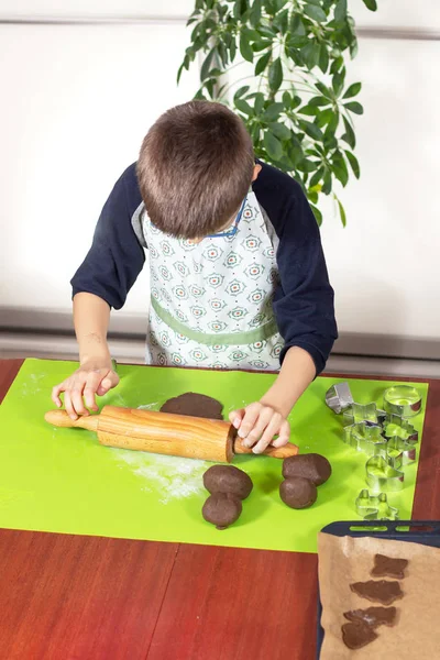 Niño Con Delantal Cocina Rodando Una Masa Marrón Con Rodillo — Foto de Stock