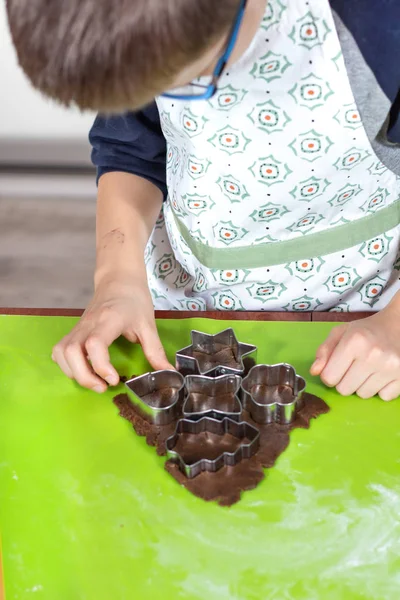 少年の手が緑色シリコン ペストリー ボード上に配置ケーキから金型から図形を絞るします 子供のための料理活動 — ストック写真