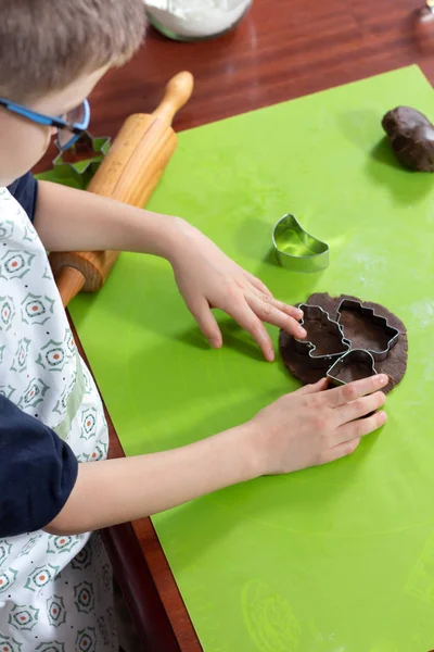 少年の手が緑色シリコン ペストリー ボード上に配置ケーキから金型から図形を絞るします 子供のための料理活動 — ストック写真