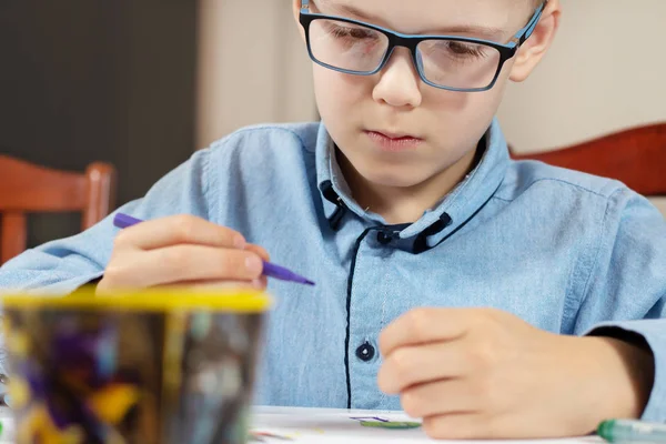 Rostro Enfocado Niño Con Una Camisa Azul Gafas Mientras Pinta — Foto de Stock