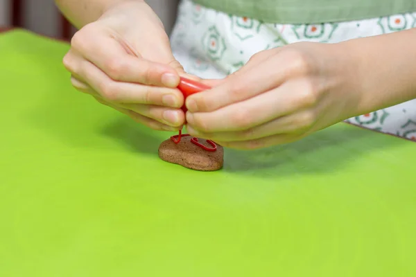 子供の手は チューブから赤いアイシングを締めます シナモンハート形クッキーデコレーション — ストック写真
