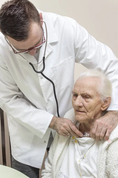 드레싱 가운을 간호사 의사가 청진기를 오래된 여성의 검사합니다 — 스톡 사진