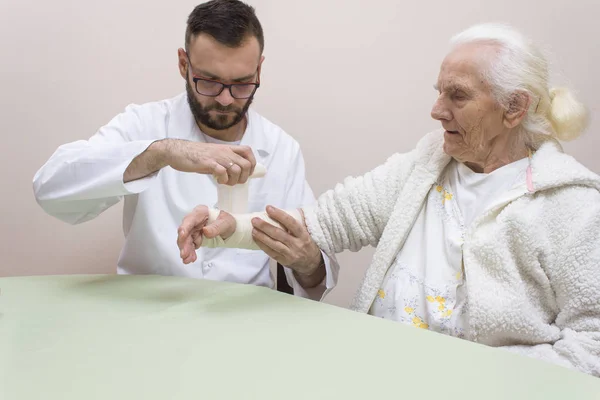 Médico Con Barba Gafas Vendan Antebrazo Elástico Una Mujer Gris — Foto de Stock