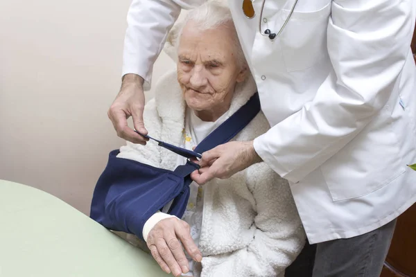 Hendene Til Ortopedisk Lege Slynge Hånden Til Svært Gammel Kvinne – stockfoto