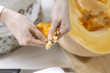 Kadın eli taze kabak çekirdeğini taze portakal kabağı özünden seçer..