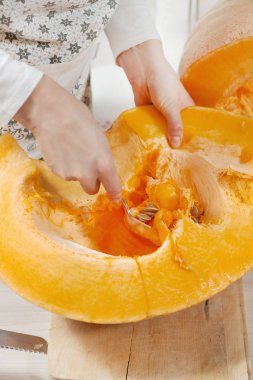 Kadının eli kesilen balkabağının ortasından çekirdekli bir çorba kaşığı seçer..