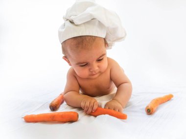 4 aylık erkek bebek, Bebek Şef, havuç, beyaz arka plan ile oynayan bebek aşçı