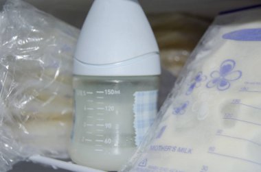 frozzen anne sütü taze expresed anne sütü, smille, emzirme kavramı ile dondurucu ve bebek şişe içinde saklanan depolama torbalarda çok