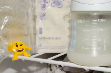 frozzen anne sütü taze expresed anne sütü, smille, emzirme kavramı ile dondurucu ve bebek şişe içinde saklanan depolama torbalarda çok
