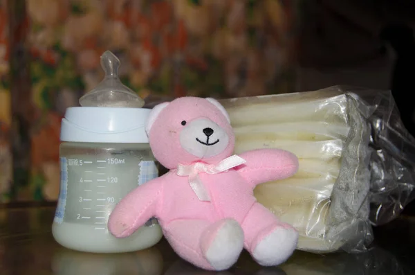 新鮮な Expresed の母乳を冷凍保存袋とピンクの柔らかいおもちゃテディベア 母乳概念で母乳と哺乳瓶 — ストック写真