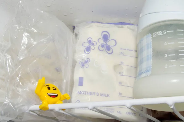 frozzen anne sütü taze expresed anne sütü, smille, emzirme kavramı ile dondurucu ve bebek şişe içinde saklanan depolama torbalarda çok