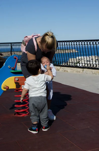 Joven Madre Rubia Sosteniendo Bebé Recién Nacido Jugando Con Niño —  Fotos de Stock