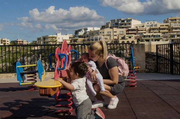 Joven Madre Rubia Sosteniendo Bebé Recién Nacido Jugando Con Niño —  Fotos de Stock