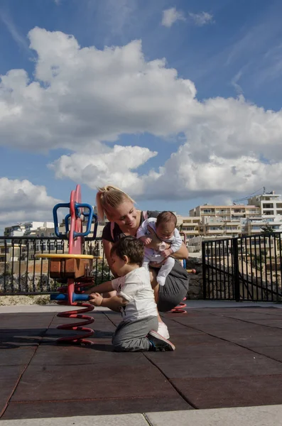 Joven Madre Rubia Sosteniendo Bebé Recién Nacido Jugando Con Niño — Foto de Stock