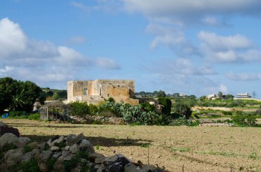 Mosta ve Burmarrad, eski taş ev ve beyaz bulutlar ile mavi gökyüzü ile arasında Malta manzara bir yere tuval